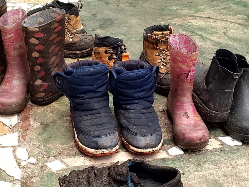 Botas y zapatillas con barro tras la labor en la tierra
